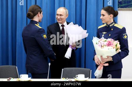 Krasnodar, Russie. 07 mars 2024. Le président russe Vladimir Poutine, au centre, présente des fleurs aux étudiantes de l'École supérieure d'aviation militaire Anatoly Serov Krasnodar à la veille de la Journée internationale de la femme, le 7 mars 2024 à Krasnodar, région de Krasnodar, Russie. Crédit : Mikhail Metzel/Kremlin Pool/Alamy Live News Banque D'Images