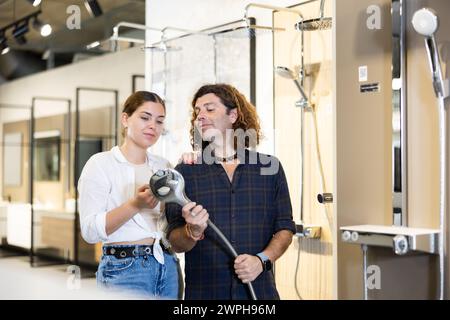 Un bon couple cherche à acheter des accessoires de douche dans le magasin de quincaillerie Banque D'Images
