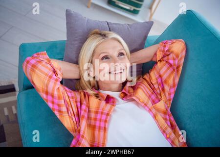 Photo de la vue au-dessus de la retraitée se reposer sur divan confortable appréciant l'appartement de maison à l'intérieur Banque D'Images