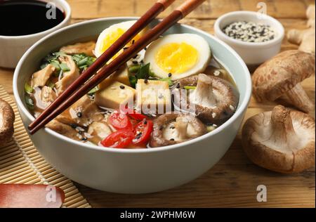 Bol de délicieux ramen et ingrédients sur la table en bois, gros plan. Soupe de nouilles Banque D'Images