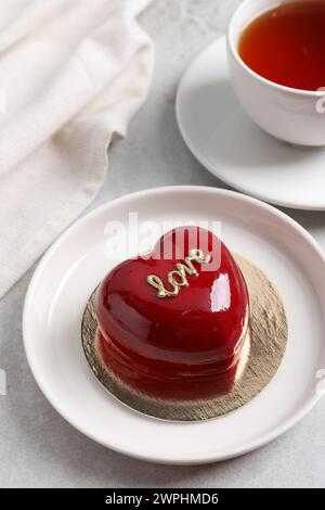 Prog Saint Valentin. Délicieux gâteau en forme de coeur servi sur une table lumineuse Banque D'Images