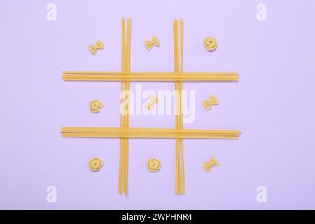 TIC tac toe jeu fait avec différents types de pâtes sur fond lilas, vue de dessus Banque D'Images