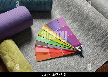 Différents rouleaux de papier peint, rouleaux et échantillons de palette de couleurs sur la table Banque D'Images