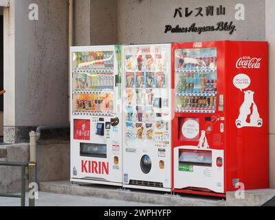 TOKYO, JAPON - 17 février 2024 : deux distributeurs automatiques de boissons (un Coca-Cola l'autre Kirin) et un distributeur de crème glacée dans un immeuble des années 1960. Banque D'Images