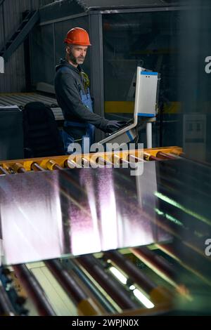 Travailleur dans un atelier travaille avec du matériel pour les fenêtres à double vitrage Banque D'Images