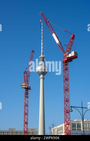 La célèbre tour de télévision de Berlin avec deux grues de construction rouges Banque D'Images