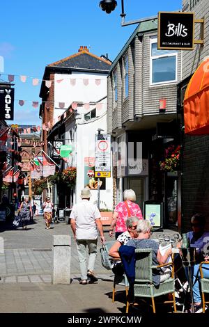 Les gens se détendent dans un café en trottoir le long de Gandy Street avec une partie du Royal Albert Memorial Museum et de la galerie d'art à l'arrière, Exeter, Devon, Royaume-Uni. Banque D'Images