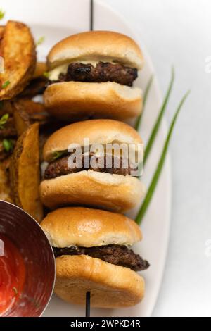 savoureux mini curseurs de hamburger sur assiette blanche avec ketchup et coins Banque D'Images