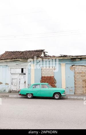 Voiture cubaine près d'un bâtiment endommagé à Santa Clara Banque D'Images