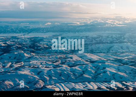 Survolant les montagnes enneigées du Colorado dans la lumière du matin. Banque D'Images