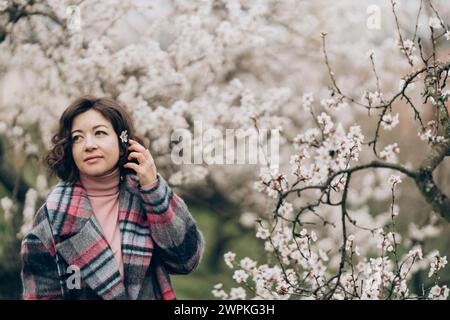 Jeune femme souriante dans un jardin d'amandiers fleuri à Prague Banque D'Images