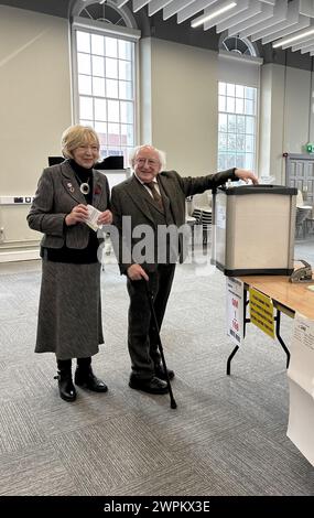 Le président irlandais Michael d Higgins et son épouse Sabina votent à Phoenix Park, Dublin, alors que l'Irlande organise des référendums sur les modifications proposées à la rédaction de la Constitution concernant les domaines de la famille et des soins. L'amendement relatif à la famille propose d'étendre le sens de la famille au-delà de celui défini par le mariage et d'y inclure les relations fondées sur des relations "durables". L'amendement CARE propose de supprimer les références aux rôles et aux devoirs de la femme au foyer et de les remplacer par un nouvel article qui reconnaît les aidants familiaux. Date de la photo : vendredi 8 mars 2024. Banque D'Images