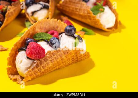 Diverses crèmes glacées au taco sucré. Coquilles de tacos à gaufrer avec glace au chocolat et à la vanille avec différents fruits, baies, garnitures Banque D'Images