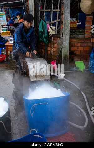 Ouvrier avec des blocs de glace au marché aux poissons de Hoi an Banque D'Images