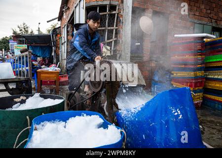 Ouvrier avec des blocs de glace au marché aux poissons de Hoi an Banque D'Images