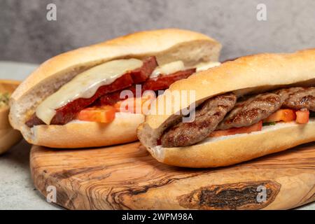Pain turc avec saucisse kashar et boulettes de viande sur le tableau de présentation. Nom local ekmek arası sucuk ve köfte Banque D'Images