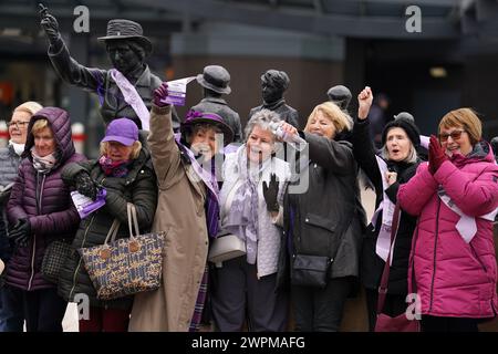 Les militantes pour les femmes contre l'inégalité des pensions de l'État (Waspis) se rassemblent devant la statue de la militante politique Mary Barbour, la femme qui a dirigé les grèves de loyer pendant la première Guerre mondiale, à Govan, Glasgow, pour marquer la Journée internationale de la femme. Date de la photo : vendredi 18 août 2023. Banque D'Images