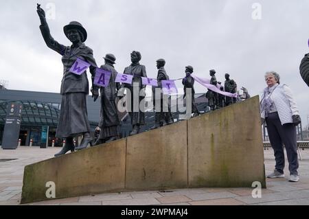 Les militantes pour les femmes contre l'inégalité des pensions de l'État (Waspis) se rassemblent devant la statue de la militante politique Mary Barbour, la femme qui a dirigé les grèves de loyer pendant la première Guerre mondiale, à Govan, Glasgow, pour marquer la Journée internationale de la femme. Date de la photo : vendredi 18 août 2023. Banque D'Images