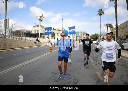 Jérusalem, Israël. 08 mars 2024. Les coureurs participent au Marathon international de Jérusalem. Les gens participent au 13e Marathon international annuel de Jérusalem à Jérusalem. Cette année, de nombreux participants portaient des chemises et couraient avec des pancartes sensibilisant aux otages enlevés le 7 octobre par le Hamas et toujours détenus à Gaza. Elle a été organisée en hommage aux Forces de défense israéliennes « IDF » et aux forces de sécurité, dans le cadre de la guerre en cours avec le Hamas à Gaza. Crédit : SOPA images Limited/Alamy Live News Banque D'Images