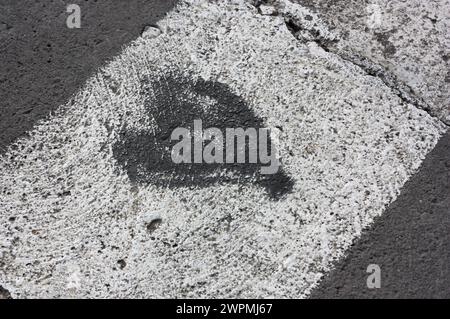 Un coeur peint sur l'asphalte à un passage piétonnier dans une ville Banque D'Images