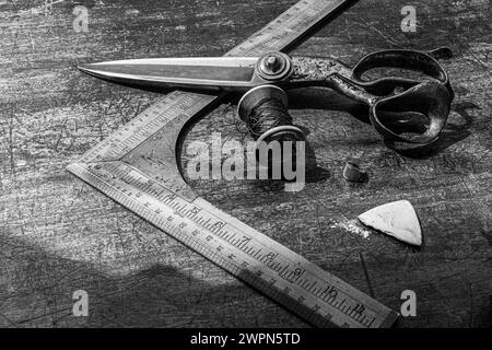 Ancien outil de mesure tailleur avec des ciseaux et de la craie sur le banc de travail tailleur Banque D'Images