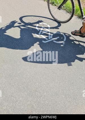 Un cycliste survole le symbole du vélo sur une piste cyclable, Allemagne Banque D'Images
