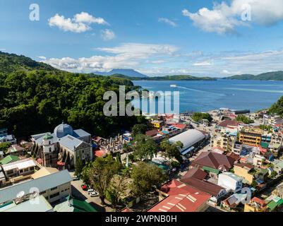 Vue aérienne des bâtiments commerciaux et des rues de l'île Romblon. Ferry sur la mer bleue. . Romblon, Philippines. Banque D'Images