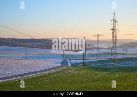 Paysage, poteaux électriques, ligne électrique, champs, neige, coucher de soleil, hiver Banque D'Images