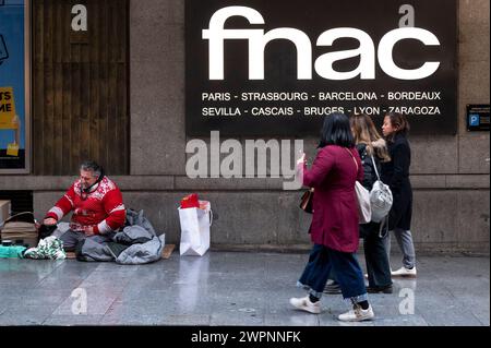 Madrid, Espagne. 14 janvier 2024. Un sans-abri est vu à l'entrée du magasin Fnac de la chaîne multinationale française d'électronique et culturelle alors que des piétons le passent devant en Espagne. (Crédit image : © Xavi Lopez/SOPA images via ZUMA Press Wire) USAGE ÉDITORIAL SEULEMENT! Non destiné à UN USAGE commercial ! Banque D'Images