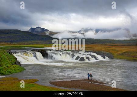Pêcheurs à la ligne un jour de pluie à la cascade de Beljandi à Breidalsdalur sur la côte est de l'Islande. Banque D'Images