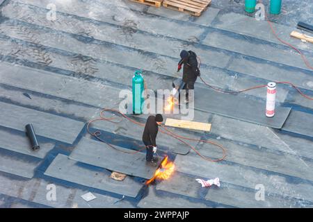 Vienne, ouvriers du bâtiment effectuant des travaux d'imperméabilisation sur un plafond de bâtiment avec des membranes de bitume en 22. Donaustadt, Wien, Autriche Banque D'Images