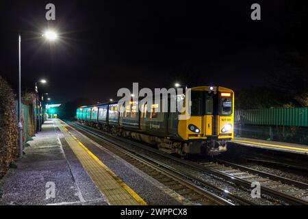 Merseyrail Electrical rétro bleu et gris livrée classe 507 troisième train électrique rail 507001 à la gare Wallasey Village la nuit Banque D'Images