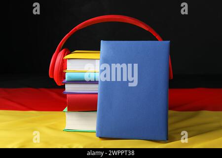 Apprendre une langue étrangère. Différents livres et écouteurs sur le drapeau de l'Allemagne Banque D'Images