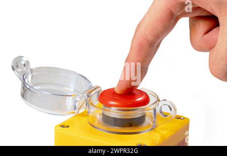 Doigt appuyant sur un grand bouton jaune rouge avec un couvercle en plastique transparent isolé sur fond blanc homme appuyant sur une machine industrielle d'urgence Banque D'Images