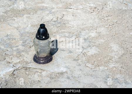 Une seule bougie votive placée sur une surface de béton gris, solitude, calme, mémoire décolorée concept abstrait simple, personne, personne, copie spac Banque D'Images