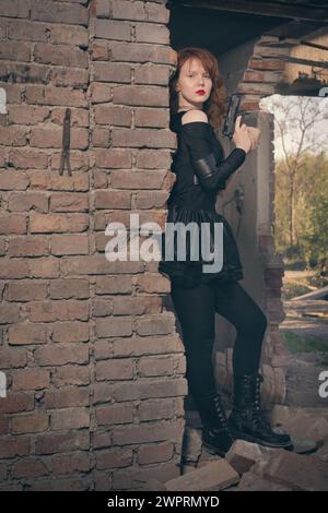 Femme combattante observant et regardant autour dans les ruines du bâtiment Banque D'Images