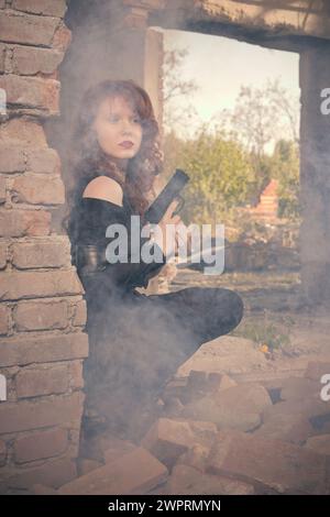 Femme combattante observant et regardant autour dans les ruines du bâtiment Banque D'Images