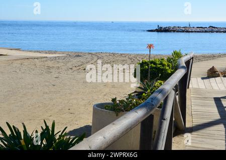 Marbella, Espagne - 10 décembre 2023 : sentier en bois à la plage lors d'une journée ensoleillée de décembre à Marbella, Andalousie, Espagne. Banque D'Images