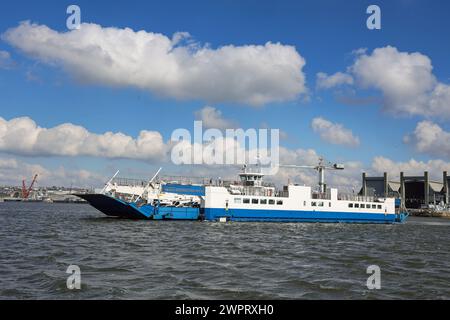 Un ferry Torpoint traversant la rivière Tamar du Devon à Cornwall. Devonport Dockyard offre une toile de fond. Banque D'Images