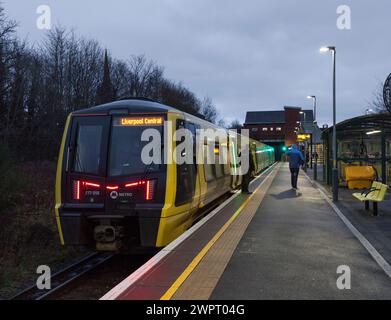 Train électrique Merseyrail Stadler classe 777 777015 à la gare de Birkenhead Park avec le conducteur surveillant les portes Banque D'Images