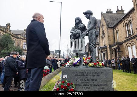 Barnsley, Royaume-Uni. 09 MARS 2024. Les gens déposent des gerbes devant le mémorial de la statue des mineurs tombés, à l'extérieur du Barnsley National Union of Mineworkers Hall à Barnsley, comomorant ceux qui ont perdu la vie pendant les grèves des mineurs 40 ans après les grèves. Crédit Milo Chandler/Alamy Live News Banque D'Images