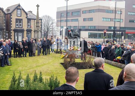 Barnsley, Royaume-Uni. 09 MARS 2024. Les gens déposent des gerbes devant le mémorial de la statue des mineurs tombés, à l'extérieur du Barnsley National Union of Mineworkers Hall à Barnsley, comomorant ceux qui ont perdu la vie pendant les grèves des mineurs 40 ans après les grèves. Crédit Milo Chandler/Alamy Live News Banque D'Images