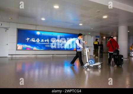 Shanghai, Chine, vues grand angle, intérieur, affiches publicitaires, aéroport moderne chinois, Hong Qiao, couloir, homme livrant de l'eau dans le couloir, devant Banque D'Images
