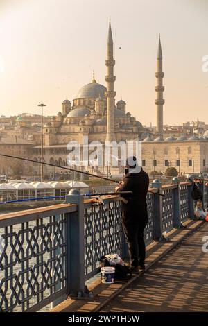 Pêcheurs à l'aube sur le pont de Galata à Istanbul, Turquie, avec la Nouvelle Mosquée en arrière-plan Banque D'Images