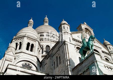 Les dômes, tours de la façade sud de la basilique du Sacré-cœur de Montmartre avec la statue de bronze de la Saint Louis à cheval, Paris, France Banque D'Images