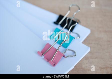 Papiers de document vierges avec trombones pastel sur table en bois. Concept de gestion des documents. Banque D'Images
