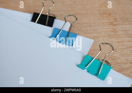Papiers de document vierges avec trombones colorés pastel sur table en bois. Concept de gestion des documents Banque D'Images