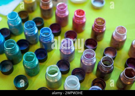 Mélange de résine époxy de couleur dans une tasse en plastique pour le moulage stabilisant le bois et l'hybride de pomme de pin. bouteilles de couleur pour art de résine Banque D'Images