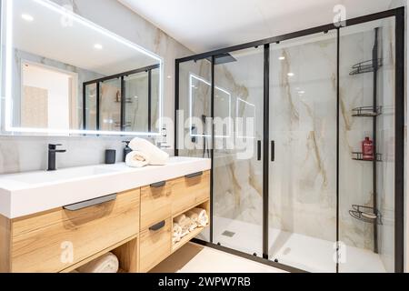 Une image en gros plan d'une salle de bain récemment rénovée avec des murs en marbre et une grande douche debout dans l'immobilier méditerranéen Banque D'Images