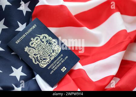 Passeport britannique bleu sur fond de drapeau national des États-Unis gros plan. Tourisme et concept de diplomatie Banque D'Images